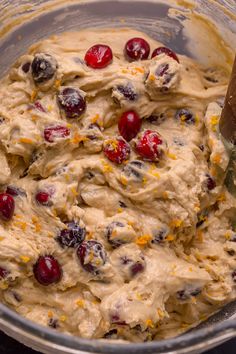 a mixing bowl filled with batter and cranberries