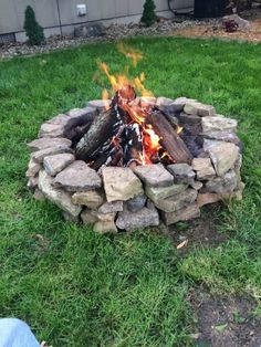 a fire pit sitting on top of a lush green field