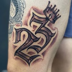 a man with a tattoo on his thigh has a crown and two dragon tattoos on his leg