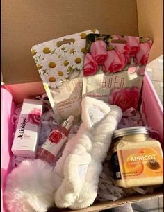 a pink box filled with lots of beauty and personal care items, including a teddy bear