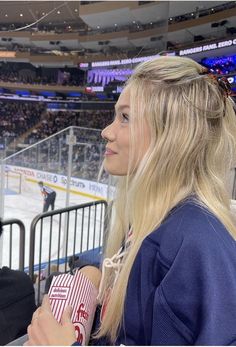 a woman sitting in front of an ice hockey rink