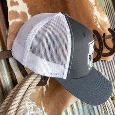 Dark grey Rodeo Ranch hat. Black and white Rodeo Ranch center patch. White mesh back. Adjustable snap back. Adjustable bill. Gray Trucker Cap, Gray Trucker Hat One Size, Gray Trucker Snapback Hat With Curved Bill, Gray Trucker Baseball Cap With Curved Bill, Gray Trucker Snapback Hat With Flat Bill, Gray Trucker Cap With Curved Bill, Gray Trucker Hat With Flat Bill, Gray Flat Bill Trucker Hat, Gray Snapback Trucker Hat One Size