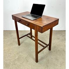 a laptop computer sitting on top of a wooden desk