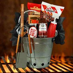 a bucket filled with food sitting on top of a bbq grill next to fire