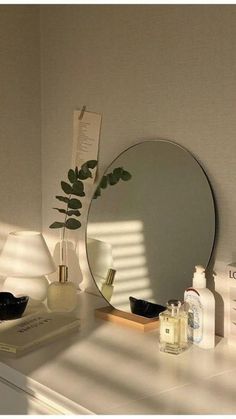 there is a mirror and other items on the counter in front of the sink, along with a plant