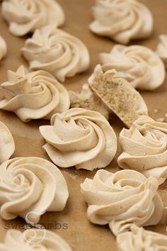 some white frosted cupcakes are sitting on a cookie sheet and ready to be eaten