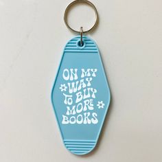 a blue keychain with the words on my way to be more books printed on it