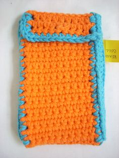 an orange and blue crocheted case with a tag on it's side