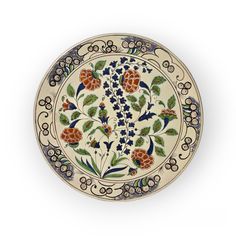 a decorative plate with flowers and leaves on it