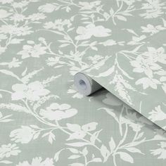 a roll of toilet paper sitting on top of a floral wallpaper