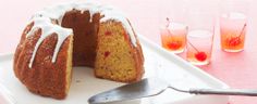 a bundt cake with white icing sitting on a plate next to a fork