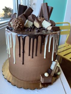 a cake with chocolate, marshmallows, and candy on it sitting on a table