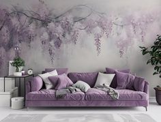 a purple couch sitting in front of a painting on the wall next to a potted plant