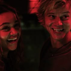 two young people are laughing together in the dark