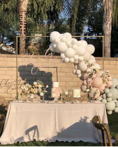 a table set up with balloons and flowers