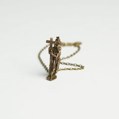 a gold chain with a cross on it and a figurine in the middle