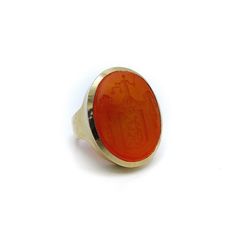 This is a spectacular carved carnelian 14 karat gold signet ring. It is part of Kirsten's Corner signature line. Starting with a beautifully carved carnelian intaglio, a simple but sophisticated 14 karat gold bezel set mount was designed. The carnelian Intaglio tablet measures 26mm x 22mm x 5mm and is bezel set. The ring has a sleek modern profile and works well as a unisex ring. The ring weighs 20.6 grams and is a size 7 1/2. It can be resized up of down a size or two.  The image on the intaglio is complex, composed of many parts. The amorial bearing pictures drapery held up by floral bouquets. In front of that is shield with a lamb holding a flag (the figure of a lamb carrying a cross and standing on a mount is the sign of Christ crucified); or Agnus Dei with the vexillum. Below the lamb Classic Carnelian Signet Ring For Formal Occasions, Classic Carnelian Signet Ring For Formal Events, Formal Carnelian Signet Ring With Polished Finish, Classic Carnelian Signet Ring With Polished Finish, Yellow Gold Carnelian Signet Ring Gift, Yellow Gold Carnelian Signet Ring As A Gift, Gift Carnelian Yellow Gold Signet Ring, Gift Carnelian Signet Ring In Yellow Gold, Formal Carnelian Oval Signet Ring