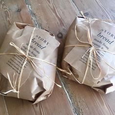 two wrapped up packages sitting on top of a wooden floor with twine tied around them