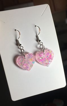 Each pair of resin earrings are handmade to order, therefore no two pairs are identical! However, I try to get as close as possible :) Made with nickel free, hypoallergenic, sterling silver plated fishhooks.  Heart width is approximately 19mm, and has pastel pink chunky mix glitter, and white holographic chunky mix glitter! Thanks for visiting my shop! 💖 Whimsical Nickel-free Heart Earrings, Pink Heart-shaped Resin Jewelry, Pink Resin Heart Earrings For Gift, Pink Resin Heart Earrings As Gift, Pink Heart Resin Earrings, Cute Pierced Heart Earrings For Gifts, Resin Heart Earrings For Gifts, Cute Pierced Heart Earrings As A Gift, Pink Resin Jewelry With Heart Charm