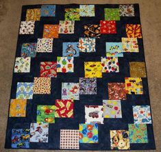 a patchwork quilt is laying on the floor in front of a carpeted area