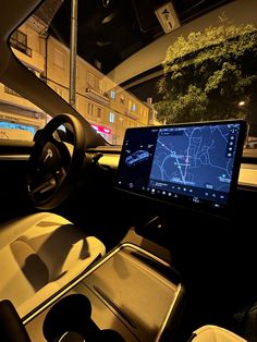 the interior of a car with a computer screen on it's dash board and steering wheel