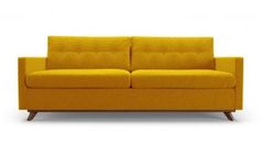 a yellow couch sitting on top of a white floor