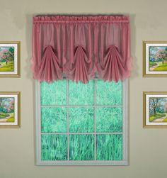 the window is decorated with pink curtains and green grass in front of it, along with pictures on the wall