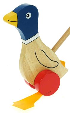 a wooden toy with a blue and yellow duck on it's head, holding a red object in its beak