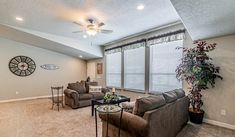 a living room filled with furniture and a ceiling fan