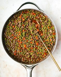 a pot filled with peas, carrots and meat