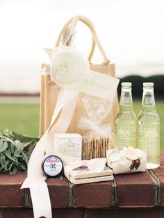 an assortment of food and drinks sitting on top of a brick wall next to a bag