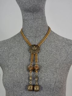 Features: - 100% Authentic JEAN PAUL GAULTIER. - Brutalist/ Tribal style necklace. - Toggle closure. - Signed JPG on reverse. - Comes with GAULTIER pouch. - Excellent vintage condition. Measurements: Pendant Drop: 7.48 inches (19 cms) Wearable Length: 16.92 inches (43 cm) **This necklace will be shipped via Priority Shipping with tracking number. Please convo me for any queries and additional photos. Thank you for visiting. Other Fees that buyers need to know: Please make sure you know and under Festival Lariat Necklace In Metal, Handmade Adjustable Vintage Chain Necklace, Adjustable Vintage Choker Chain Necklace, Antique Finish Medallion Necklaces, Adjustable Medallion Necklace With Antique Finish, Vintage Antique Gold Necklaces For Festival, Vintage Antique Gold Necklace For Festival, Adjustable Brass Necklace With Antique Finish, Adjustable Metal Necklace With Vintage Charm