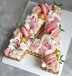 a cake shaped like the letter n is decorated with pink and white icing flowers