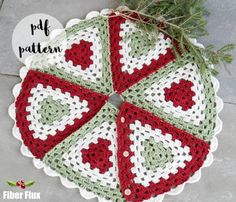 a crocheted doily with red, green and white hearts on the center