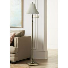 a floor lamp in a living room next to a couch