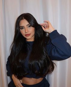 a woman with long black hair is posing for the camera