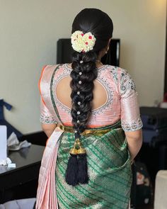 a woman with long hair wearing a green and pink sari