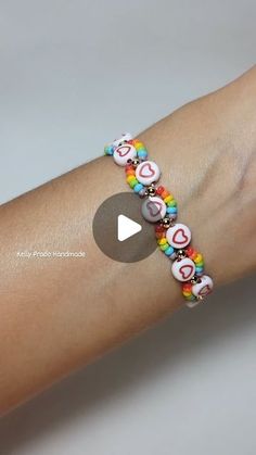 a woman's arm with a bracelet made out of beads and hearts on it