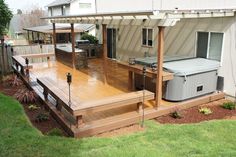 an outdoor hot tub on a deck next to a house