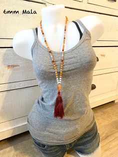 "A wonderful Mala for helping with insecurities. Handcrafted with Aquamarine for support when feeling overwhelmed and Peach Aventurine for assistance when making decisions. This Mala also consists of Sunstone which is known as a stone of leadership and personal power along with Carnelian to calm temper and give a sense of humor. An accent stone of Citrine is worked in for joy and happiness. All these healing stones are hand knotted into this beautiful 108 bead Mala. Charm not included, please se Bohemian Orange Jewelry For Meditation, Bohemian Orange Hand-strung Necklace, Amber Crystal Necklace For Meditation With Natural Stones, Spiritual Hand-strung Amber Beaded Necklaces, Spiritual Amber Beaded Necklaces With Natural Stones, Spiritual Amber Beaded Necklace With Natural Stones, Adjustable Hand-strung Carnelian Beaded Necklaces, Bohemian Amber Crystal Necklace For Meditation, Bohemian Orange Crystal Necklace With Natural Stones