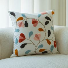 a white couch with a colorful pillow on it