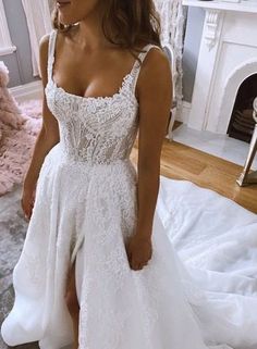 a woman in a white wedding dress standing on a bed