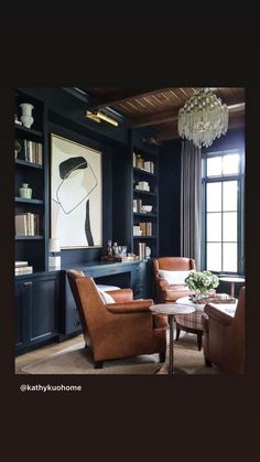 a living room filled with furniture and a chandelier hanging from the ceiling above it