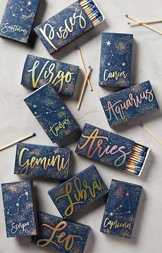 some matches are laying on top of each other with the words zodiac matches in gold and blue