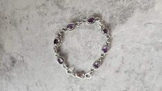 Elevate your style with the timeless elegance of this Genuine Amethyst and 925 Sterling Silver Bracelet, measuring 7 inches in length. Crafted with care, this bracelet showcases the natural beauty of amethyst stones, each carefully set in sterling silver. Whether as a gift for a loved one or a treat for yourself, its handmade design adds a personal touch, making it a perfect accessory for any occasion. Embracing the latest trends with a boho-chic flair, it effortlessly captures the essence of mo Classic Sterling Silver Crystal Bracelet For Wedding, Wedding Sterling Silver Adjustable Bracelet, Stamped 925 Sterling Silver Wedding Bracelet, Wedding Sterling Silver Bracelet Stamped 925, Sterling Silver Crystal Gemstone Bracelet For Wedding, Sterling Silver Gemstone Bracelets For Weddings, Handmade Sterling Silver Round Bracelet For Wedding, Handmade Sterling Silver Bracelet For Wedding, Elegant Amethyst Bracelets For Wedding