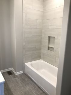 a white bath tub sitting inside of a bathroom next to a walk in shower stall