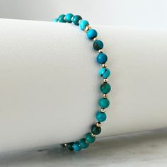 Step into a world of understated elegance with our Genuine Turquoise & Solid Gold Minimalist Bracelet. This exquisite piece features guaranteed 100% natural high-quality 4mm round natural turquoise beads, enhanced with 2mm solid yellow gold beads. Its minimalist design complements any outfit, adding a sophisticated touch to your daily wear. Bracelet Pack, Awareness Bracelet, Natural High, Bracelet Design, Minimalist Bracelet, Genuine Turquoise, Understated Elegance, Natural Turquoise, Glass Necklace