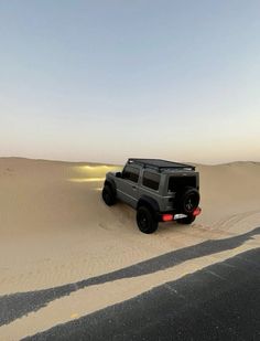 a jeep driving through the sand dunes in the desert