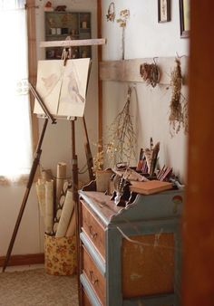 an easel sitting on top of a dresser next to a window