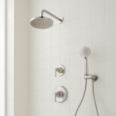 a shower head with thermostaer and hand held shower faucet in front of it